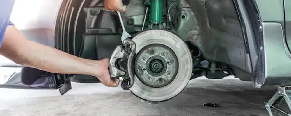 a person holding a wrench on a car