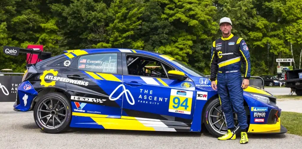 a man standing next to a race car