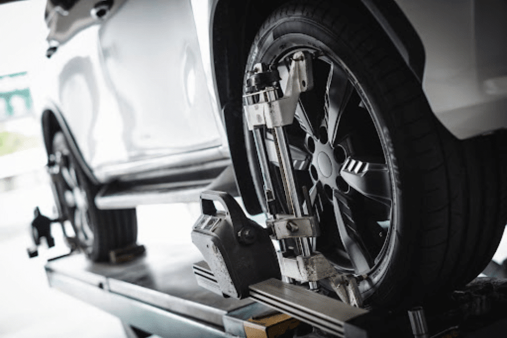 tire care, european auto repair in Gainesville, GA at Atlanta Speedwerks. Wheel alignment equipment attached to a car's tire on a lift.