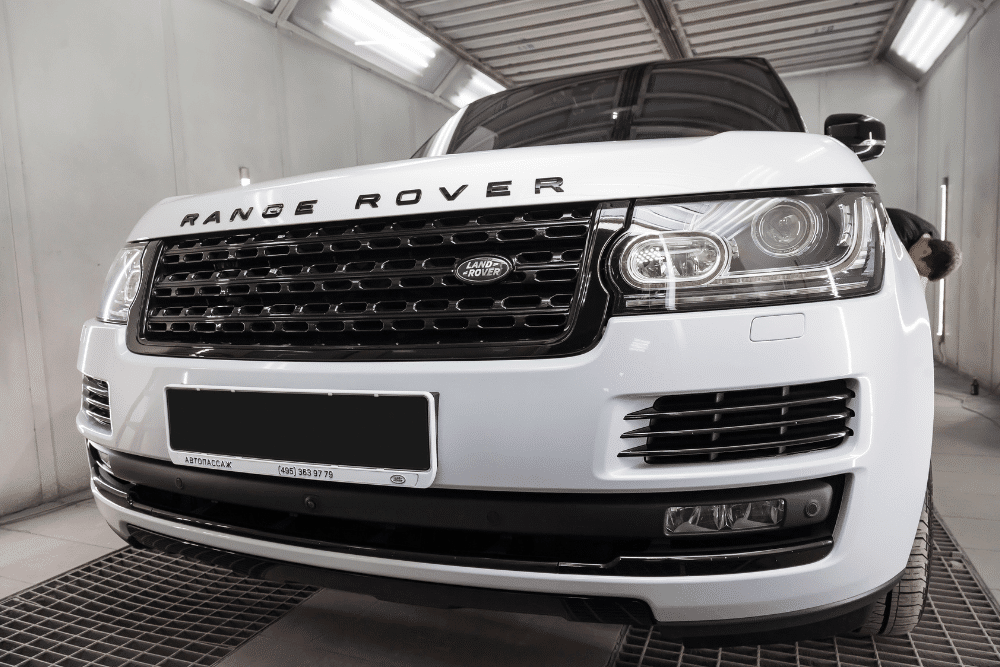 range rover reliability, auto repair in Gainesville, GA at Atlanta Speedwerks. White Range Rover inside a professional auto detailing or repair booth.