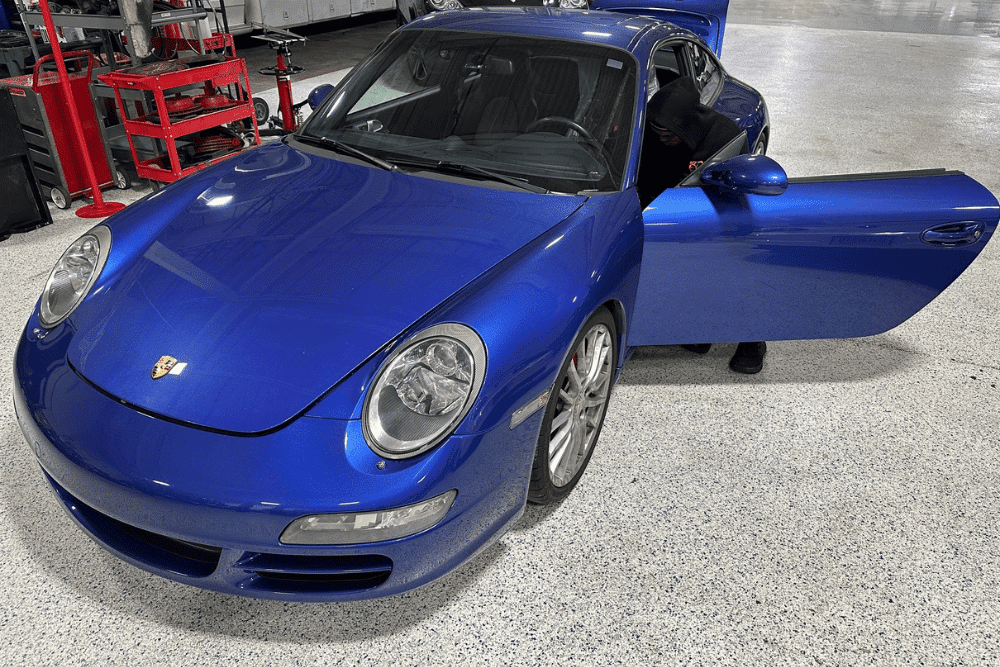 Porsche repair in Gainesville, GA by Atlanta Speedwerks. Image of a vibrant blue Porsche 911 undergoing interior diagnostics on a clean shop floor.