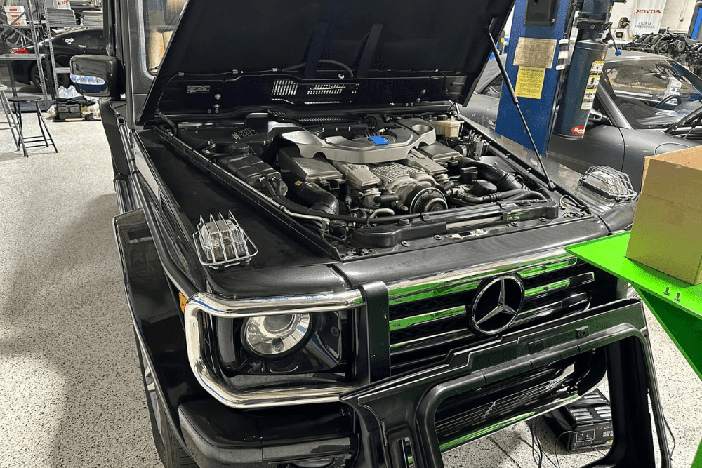 European auto repair specialist in Gainesville, GA by Atlanta Speedwerks. Image showing a black Mercedes G-Wagon with the hood open during engine diagnostics, emphasizing professional European auto repair and maintenance services.