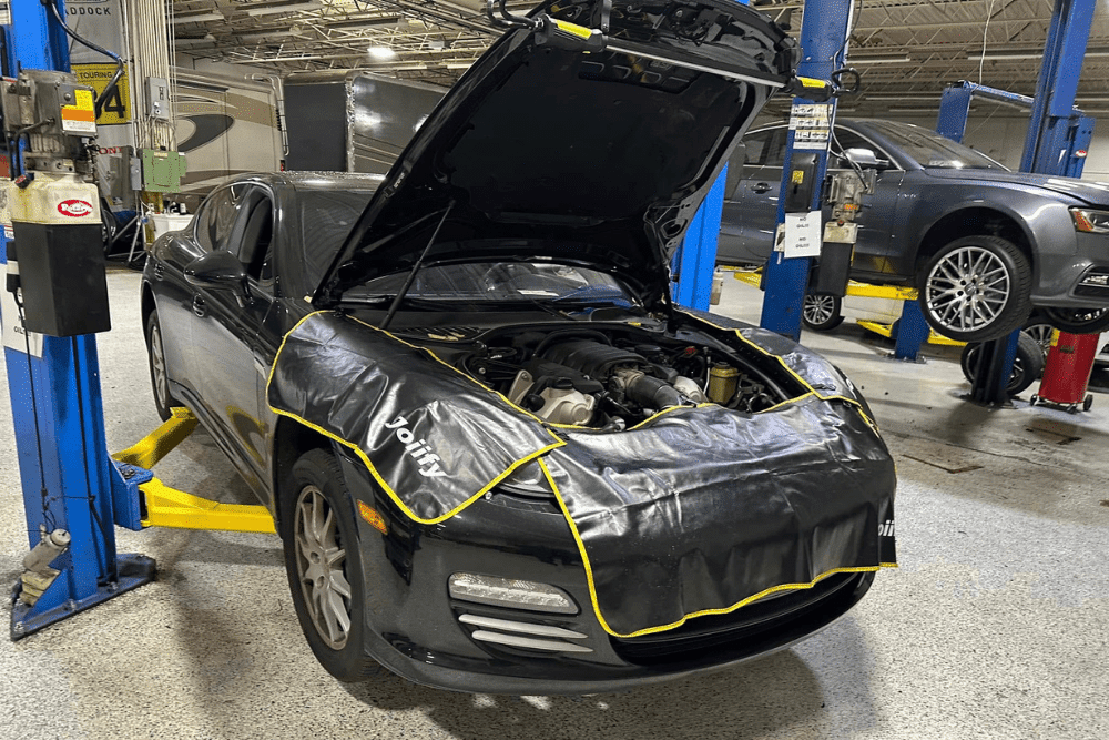 Car maintenance, auto repair in Gainesville, GA by Atlanta Speedwerks. Image of a Mazda sports car on a lift with the hood open and protective fender covers in place. Highlighting Atlanta Speedwerks’ commitment to precision maintenance and reliable performance for Mazda drivers.