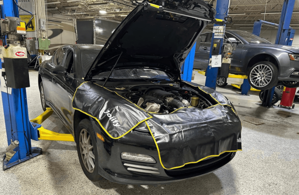 Car maintenance, auto repair in Gainesville, GA by Atlanta Speedwerks. Image of a Mazda sports car on a lift with the hood open and protective fender covers in place. Highlighting Atlanta Speedwerks’ commitment to precision maintenance and reliable performance for Mazda drivers.