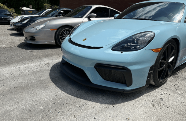 european car brands, european auto repair in Gainesville, GA at Atlanta Speedwerks. Light blue Porsche Cayman GT4 parked among other Porsche sports cars.