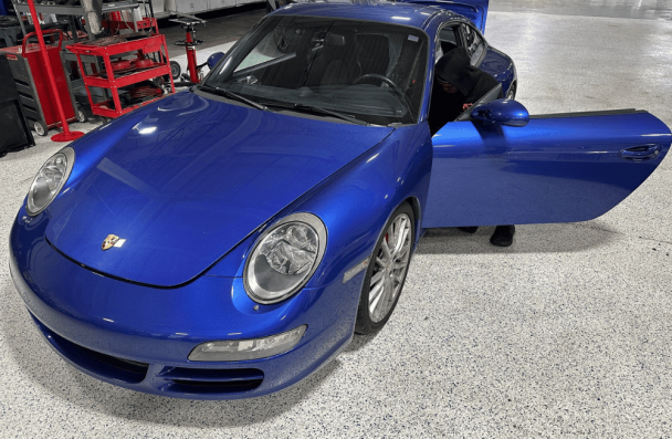 Porsche repair in Gainesville, GA by Atlanta Speedwerks. Image of a vibrant blue Porsche 911 undergoing interior diagnostics on a clean shop floor.