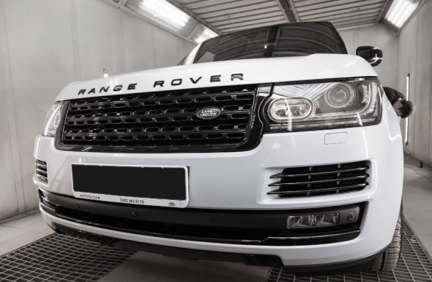 range rover reliability, auto repair in Gainesville, GA at Atlanta Speedwerks. White Range Rover inside a professional auto detailing or repair booth.