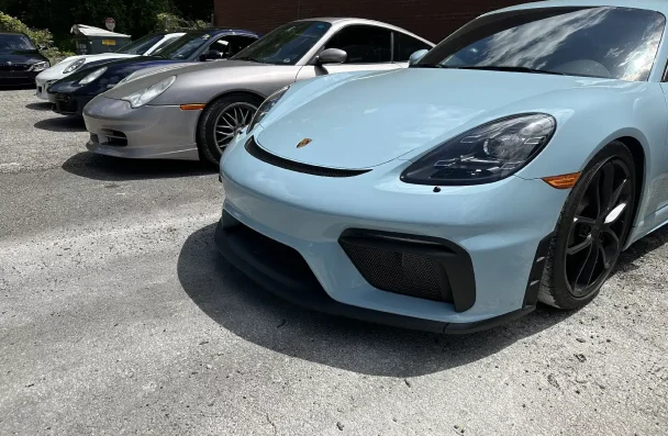 Porsche repair and maintenance in Gainesville, GA by Atlanta Speedwerks. Image of a light blue Porsche Cayman parked, showcasing the car's sleek design and suitability for daily driving with proper care and maintenance.