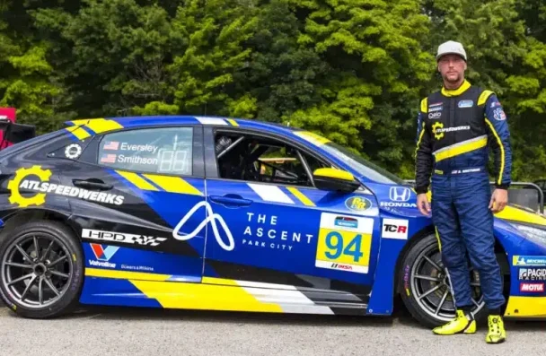 a man standing next to a race car