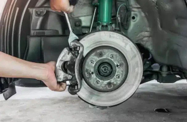 a person holding a wrench on a car