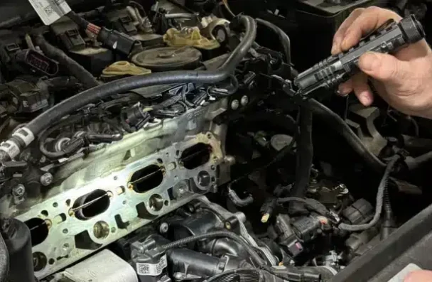 a person holding a tool in a car engine