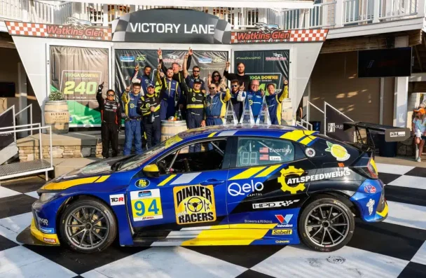 a group of people standing in front of a race car